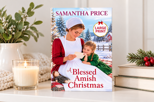 A large print hardcover book titled 'A Blessed Amish Christmas' by Samantha Price, displayed on a white shelf with a lit candle, greenery, and books in the background.
